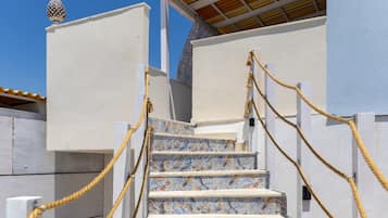 A set of stairs with a patterned tile design leading to a building entrance.
