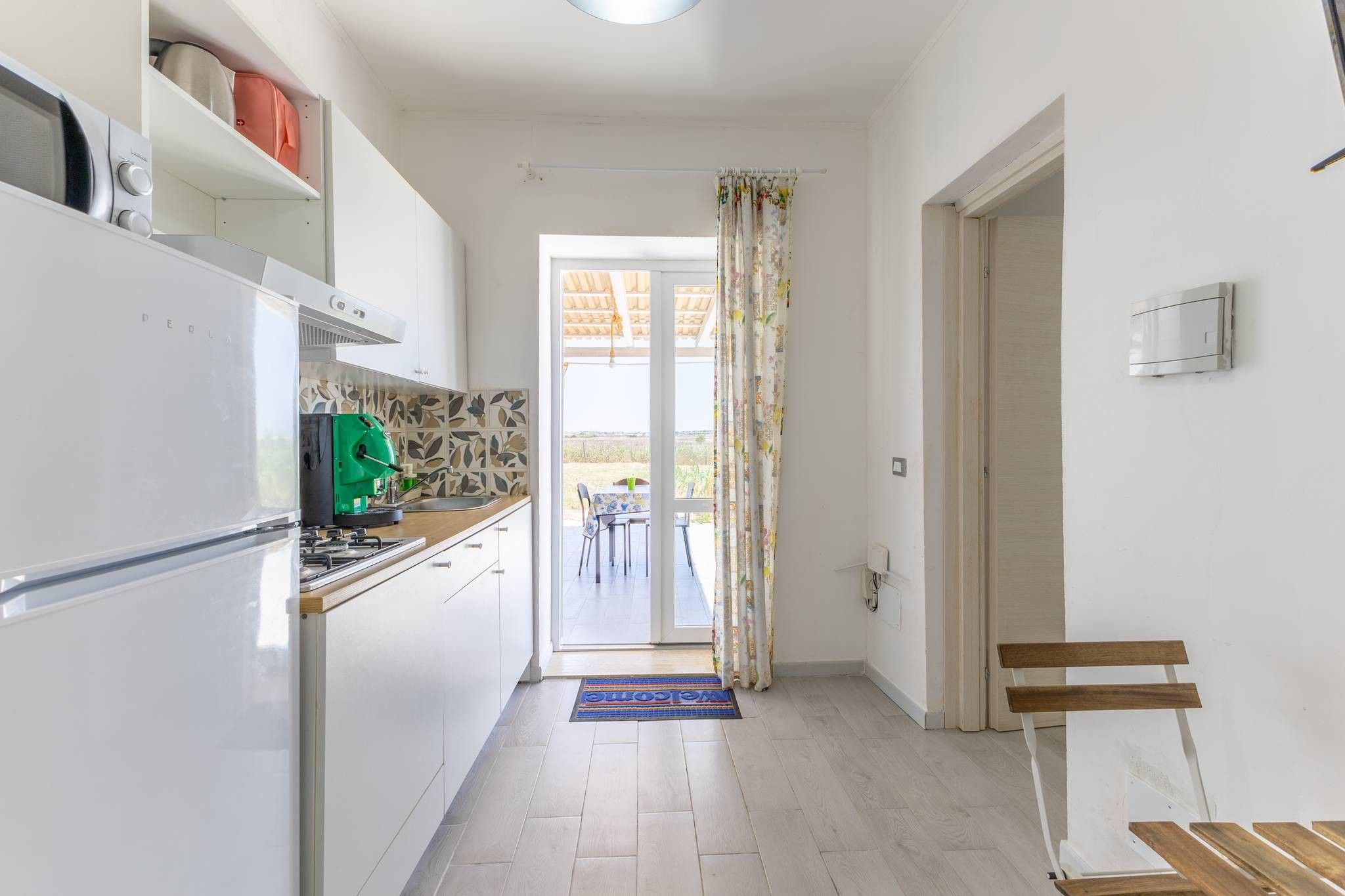 A kitchen with a refrigerator, stove, and a green water dispenser.