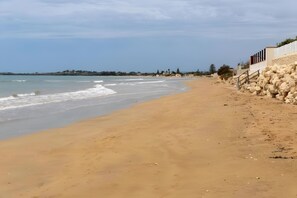 A sandy beach with a rocky wall and a clear sky. - Apartment 'Savana Gialla' with Private Terrace and Wi-Fi (Granelli)