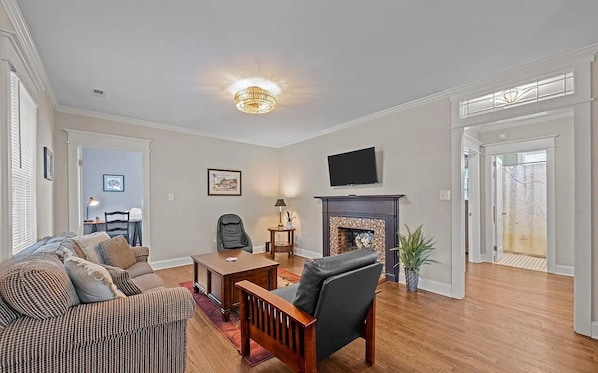Una sala de estar con chimenea, televisor y sofá.
