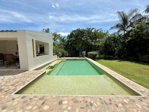A rectangular swimming pool with a tiled edge, surrounded by a stone patio. - Cuernavaca -Casa las Berthas - Estilo Contemporáneo (Tezoyuca)