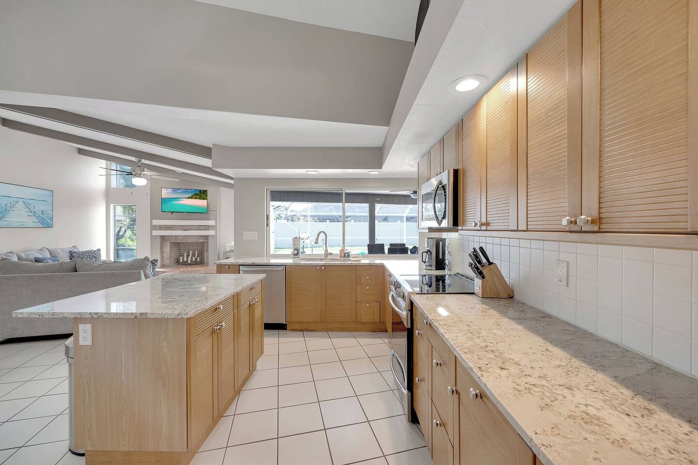 Une cuisine moderne dotée d’un îlot central, de meubles en bois et d’une grande fenêtre.