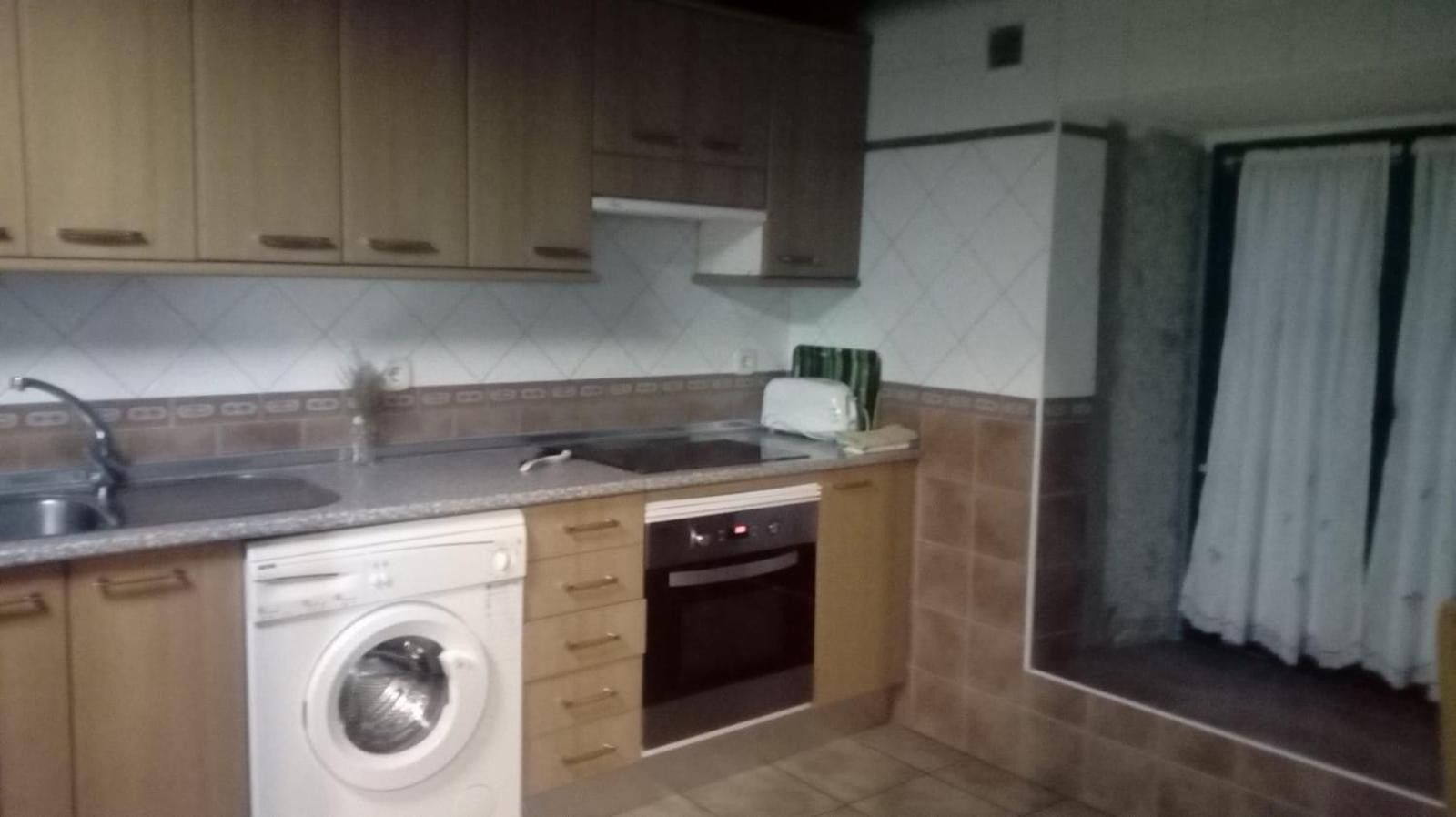A compact kitchen with a washing machine, a dishwasher, and a built-in oven.
