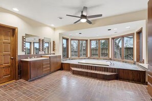 Un bagno spazioso con un ampio lavabo, una vasca freestanding e un ventilatore a soffitto.