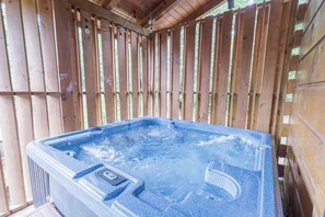 Ein Whirlpool mit Bedienfeld, umgeben von einem Holenzaun.