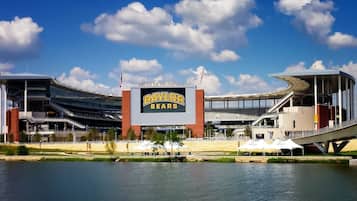 A stadium with a large sign reading 'BAYLOR BEARS' and a flagpole with an American flag.