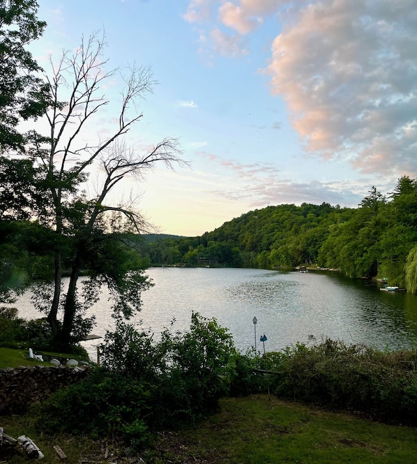 Um lago rodeado por floresta densa e um muro de pedra.