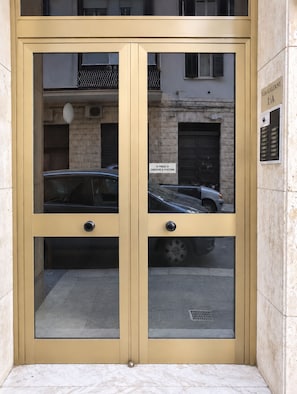 A double door entrance with a sign above indicating a parking area. - Central home near Bari station (Bari)