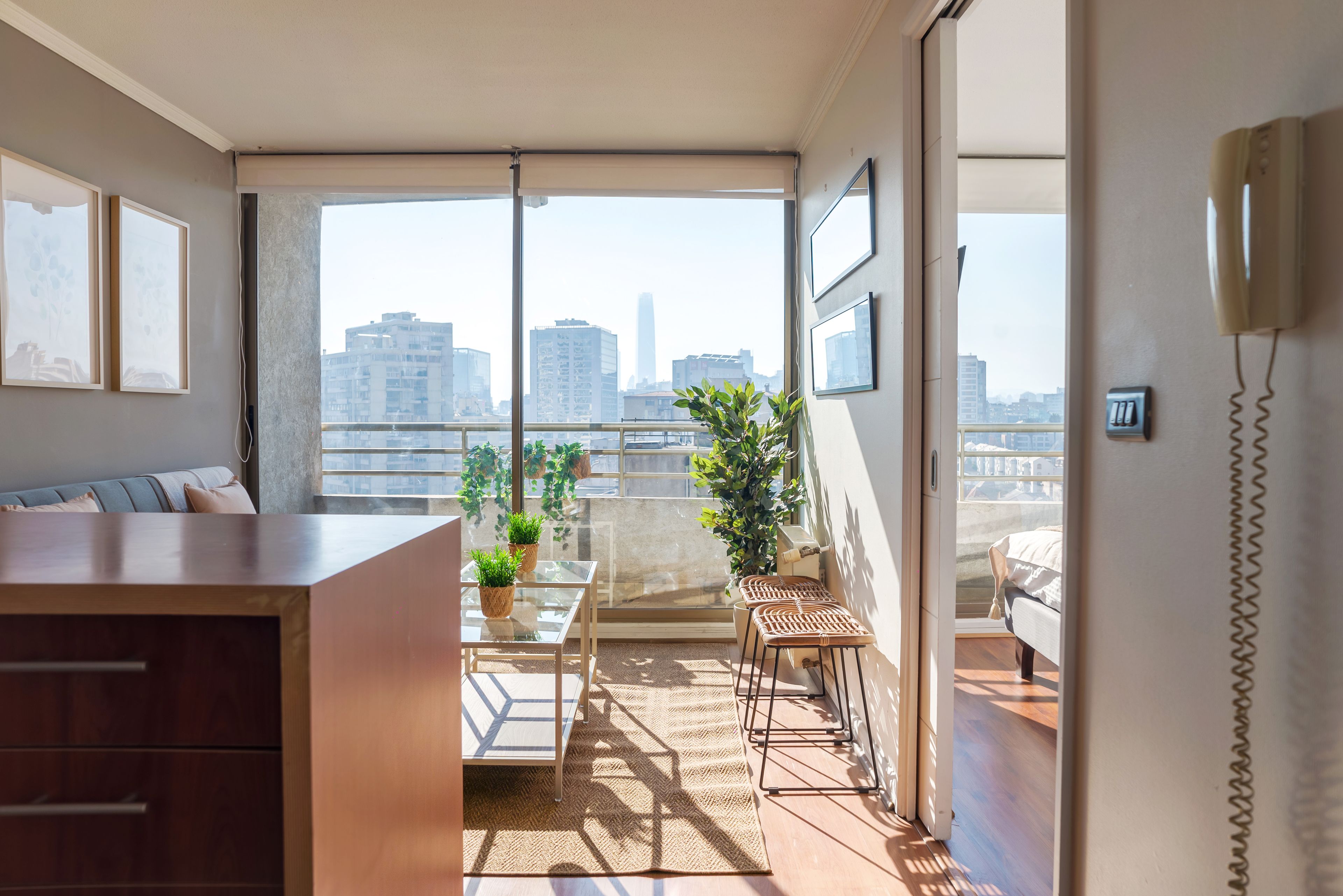 A modern apartment with a balcony, a dining area, and a view of the city skyline.