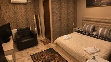 Une chambre avec un lit, un canapé, un bureau et un tapis à motifs léopard.