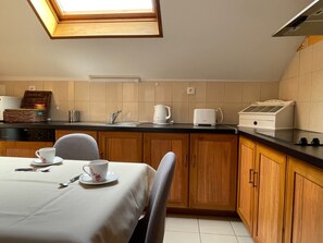 Una cucina compatta con zona pranzo, dotata di tostapane, bollitore e piccolo frigorifero.