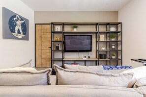 A modern living room with a flat-screen TV, a bookshelf, and a couch. - Private Oasis in Querétaro (Santiago de Querétaro)