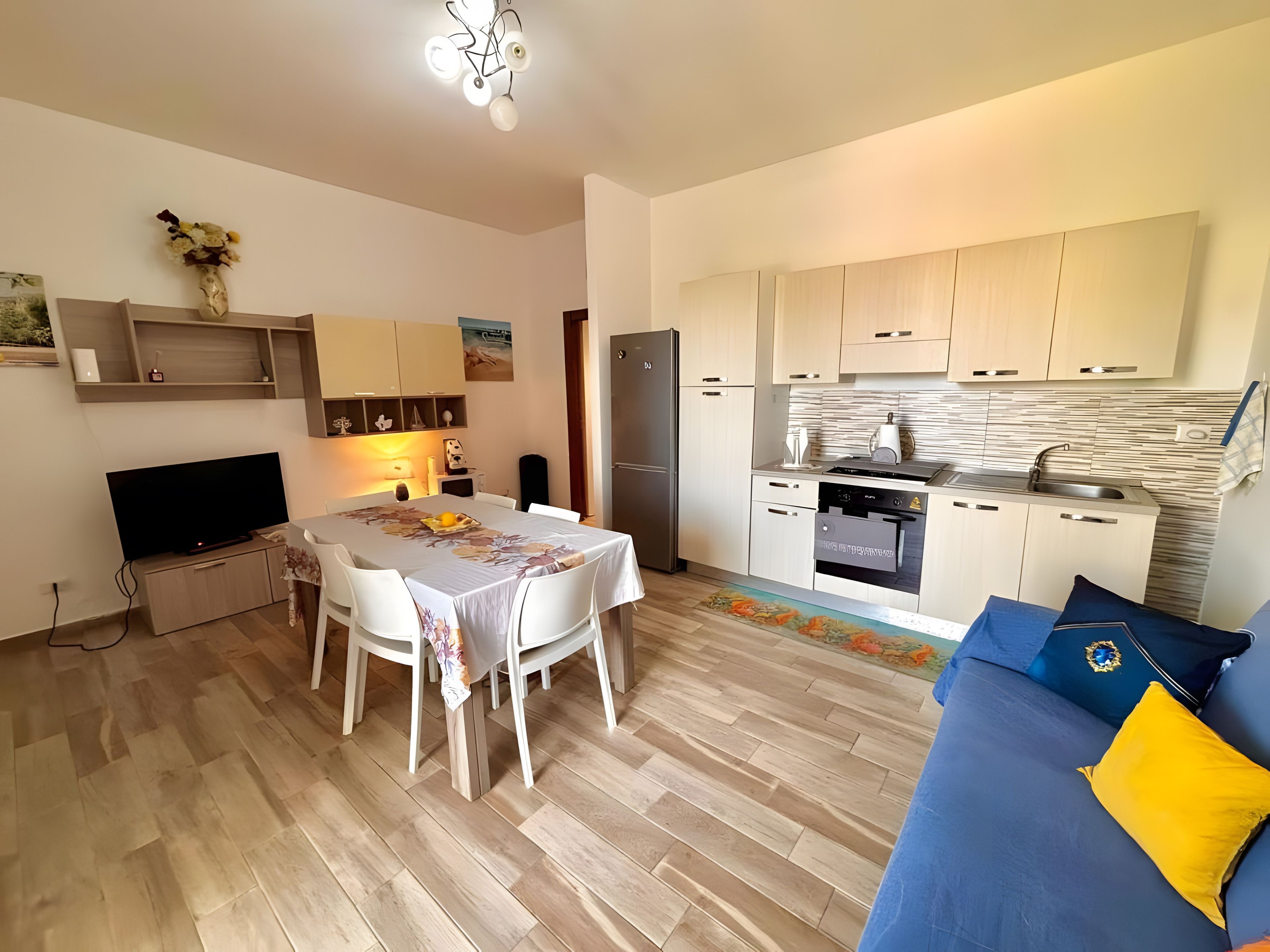 A modern apartment with a dining area, kitchen, and living space.