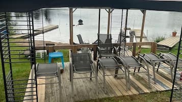 A covered outdoor seating area with a view of a lake.