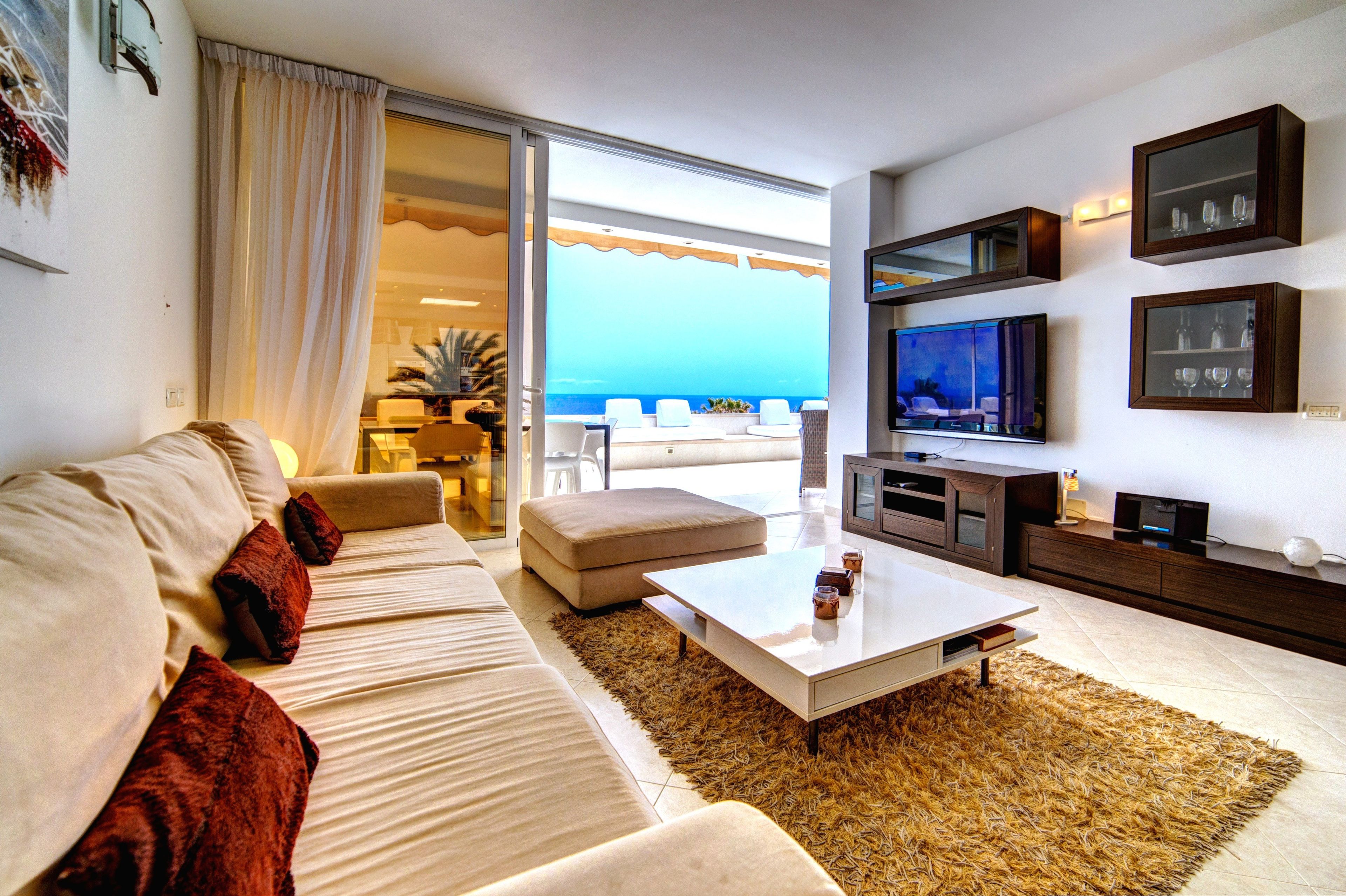 A modern living room with a sofa, coffee table, and entertainment unit.