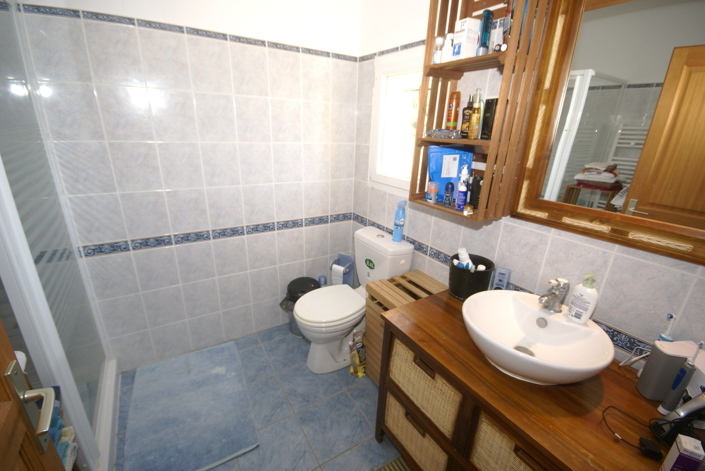 A bathroom with a toilet, sink, and mirror.