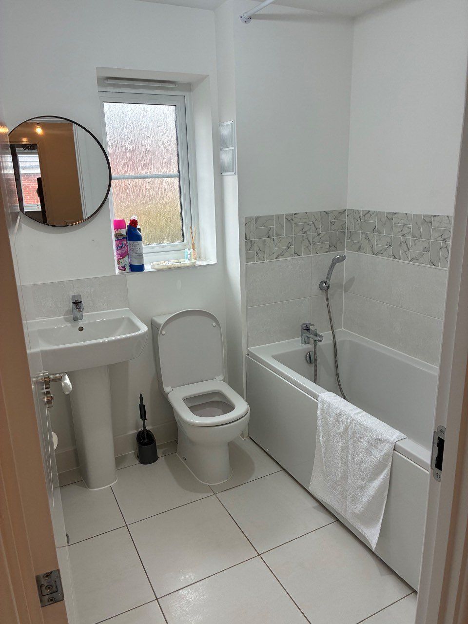 A bathroom with a toilet, sink, and bathtub.