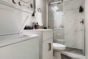 Ein modernes Badezimmer mit einem weißen Waschtisch, einer Toilette und einer Duschkabine.