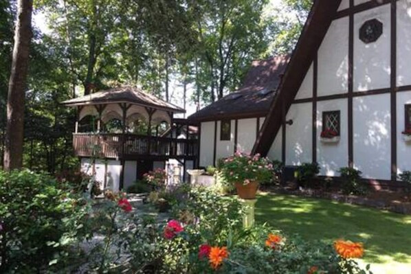 A traditional half-timbered building with a garden in front. - Acorn Cottage at Saluda River Farms (Greenville)