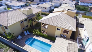 A residential area with multiple two-story buildings, a swimming pool, and outdoor seating. - Etx-AlessandroCrivellaro (Porto Seguro)