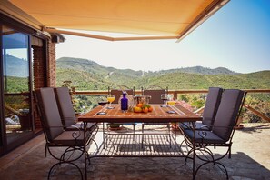 A terrace with a table set for two, overlooking a mountainous landscape. - Country House 'Villa Fernandez' with Mountain Views, Wi-Fi and Air Conditioning (Ojén)