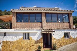 A two-story building with a stone facade, a tiled roof, and a small entrance with a door. - Country House 'Villa Fernandez' with Mountain Views, Wi-Fi and Air Conditioning (Ojén)