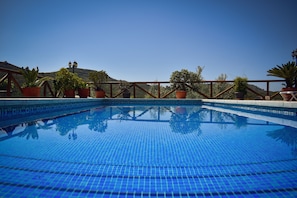 A clear blue pool surrounded by a wooden fence with potted plants. - Country House 'Villa Fernandez' with Mountain Views, Wi-Fi and Air Conditioning (Ojén)