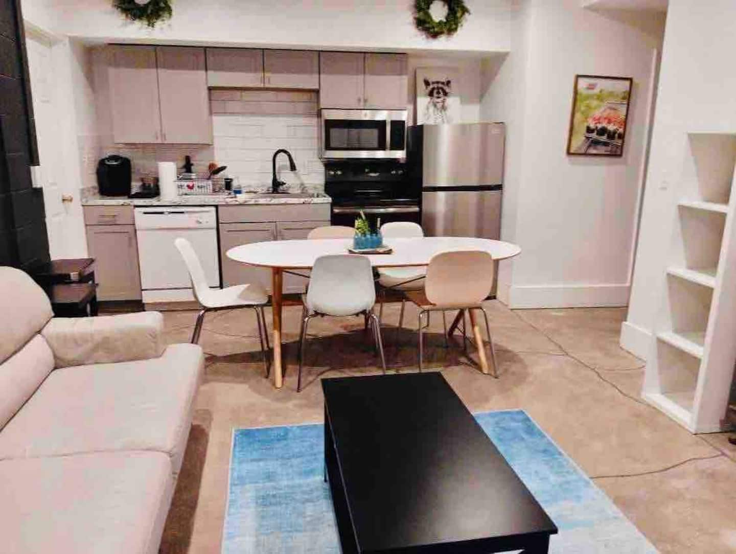 A compact living space with a kitchenette, dining area, and a sofa.