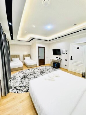 A modern hotel room with a large bed, a desk, a television, and a wardrobe. - The Moonya Hotel (Samarqand)