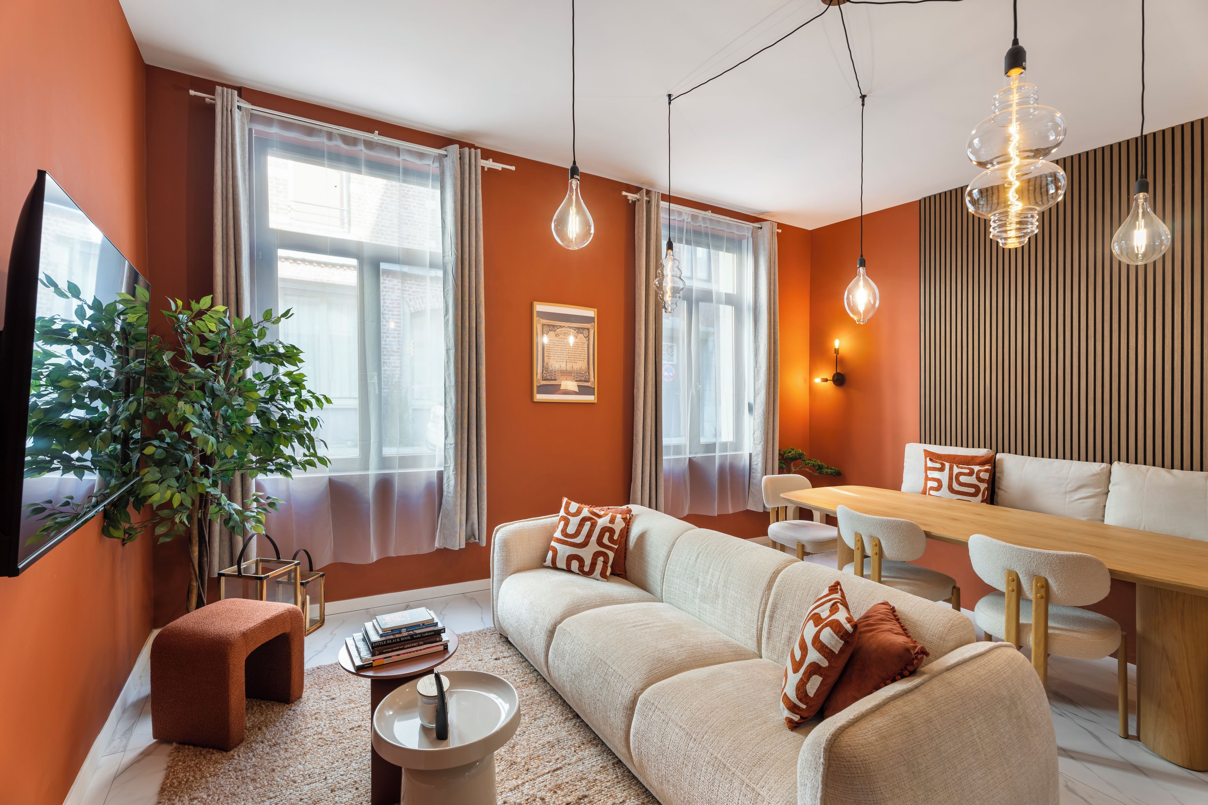 A modern living room with a sofa, coffee table, and dining area.