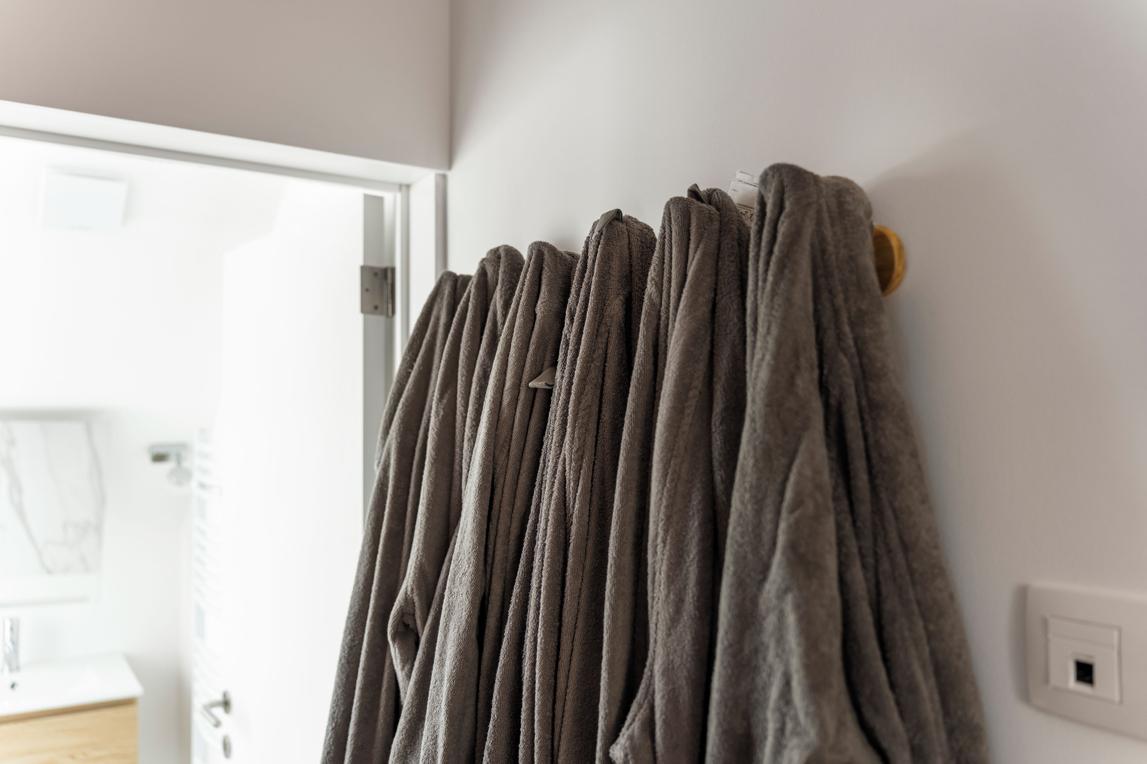A bathroom with a towel rack holding several towels.