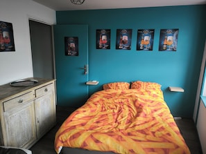 Ein Schlafzimmer mit einem Bett, einem Schminktisch und Wandbildern.