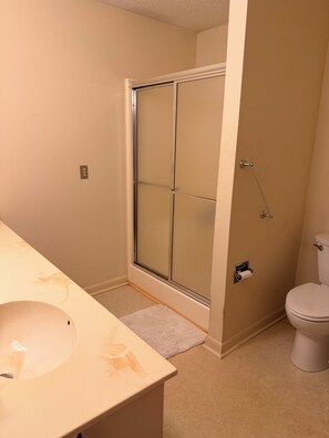 A bathroom with a shower, toilet, and sink. - The Sunset House, your home away from home. (Nashville)