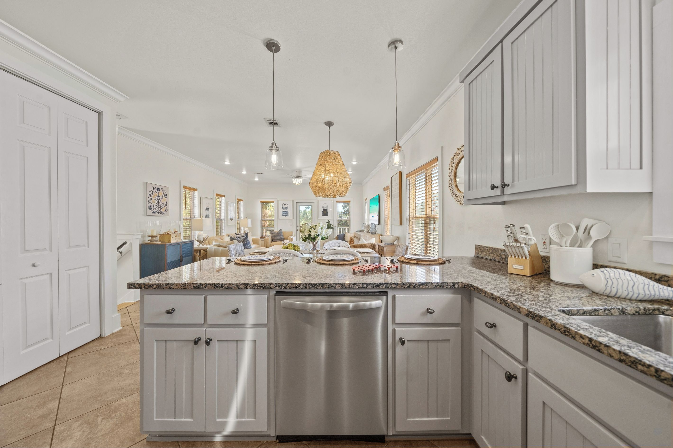 A spacious kitchen with a large island, stainless steel appliances, and a variety of decorative items.