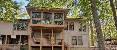 A two-story house with a balcony, a porch, and a deck.