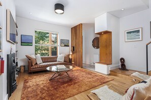 A modern living room with a leather sofa, a glass coffee table, and a large window. - 3 bed · 2 bath · Sauna · Garden · 2 Car Parking Pad (Toronto)