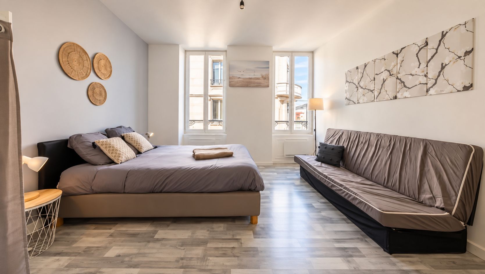 Une chambre à coucher avec un lit, un canapé, une table de chevet et une lampe.