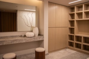 A bathroom with a mirror, a vase, and a wooden cabinet. - New Listing (Zapopan)
