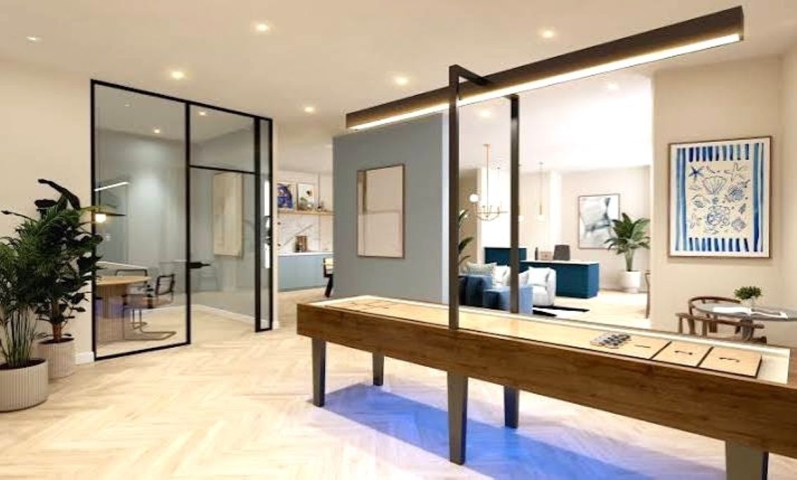 Un interior moderno con un banco de madera, divisiones de vidrio y un comedor con sillas y una mesa.