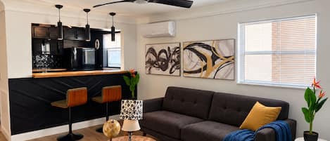 A modern living room with a dark grey sofa, a round coffee table, and a globe lamp.