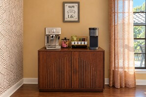 Un mueble de madera con una cafetera y un Keurig encima.