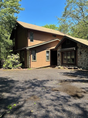 A two-story building with a stone facade and a sloped roof. - Charming 4-Bedroom Cabin in Lake Harmony, PA PERFECT for your next getaway! (Lake Harmony)