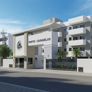A modern building with a sign reading 'PORTO CARAVELAS'. - Apartamento Completo Praia Canasvieiras (Florianópolis)
