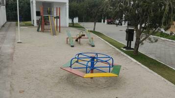 A playground with a swing set and a climbing structure.