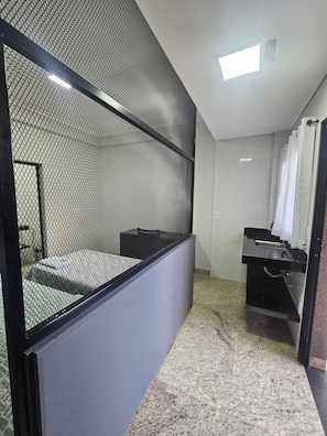 A modern bathroom with a shower, a sink, and a toilet. There is a partition with a mesh design. - Estância Ana S Diniz (Barretos)