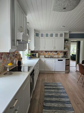 Una cocina moderna con armarios blancos, una isla central y un salpicadero con diseño.