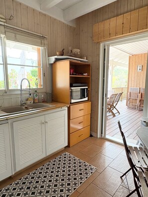 Eine Küche mit einem Holzkorpus, einer Mikrowelle und einem Spülbecken.
