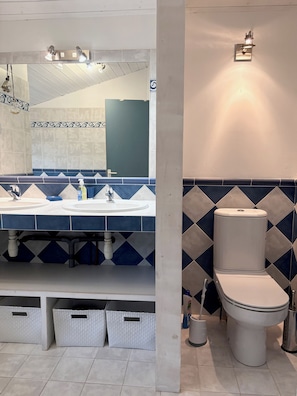 A bathroom with a large mirror, two sinks, a toilet, and storage baskets. - New Listing (La Teste-de-Buch)