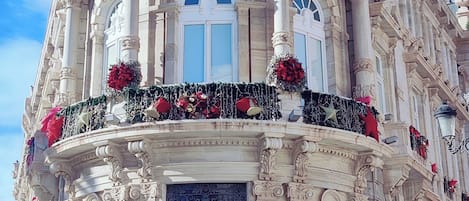 Un edificio histórico con una cúpula destacada, columnas ornamentadas y una entrada principal con un portón negro.