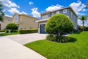 A residential area with modern houses, a paved driveway, and well-maintained lawns. - ECR7537 - MagicVilla Retreat, Theater @Encore (Kissimmee)